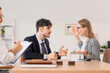 © Pixel-Shot - Male business mediator working with arguing clients at table in office