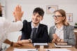 © Pixel-Shot - Male business mediator giving high-five to clients at table in office