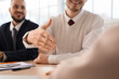 © Pixel-Shot - Business man reaching out hand for handshake at mediator's office, closeup