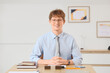 © Pixel-Shot - Young redhead businessman at desk in office