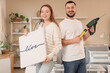© Pixel-Shot - Young couple with poster and tools at home