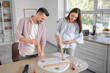 © Pixel-Shot - Happy pregnant couple assembling table in kitchen
