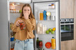 © Pixel-Shot - Young woman with spoiled canned food near open fridge in kitchen