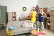 © Pixel-Shot - Young janitors in Santa hats cleaning room after New Year party