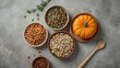 © VolumeThings - Bowls of sunflower and pumpkin seeds on a gray tabletop, top view