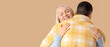 © Pixel-Shot - Young man hugging his mother on beige background