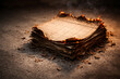 © Sourov943 - Stack of old, charred documents on a concrete floor, with embers and smoke