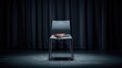 © VolumeThings - Vacant contemporary chair on stage next to a closed notebook and microphone, with a dark curtain hinting at an upcoming presentation or interview