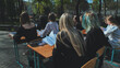 © Довидович Михаил - High school students focus on their studies at outdoor desks on a gorgeous sunny day