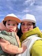 © phpetrunina14 - Mother holding toddler outdoors under blue sky Portrait