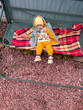 © phpetrunina14 - Smiling toddler in beanie sitting on plaid blanket outdoors Overhead top view