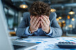 © snezhkina - Man in suit holding head in hands over desk with financial reports and calculator