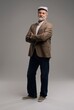 © opolja - Full length body size view of attractive serious grey-haired man in suit and flat cap isolated on grey