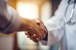 © DSimage - Close-up of a doctor and patient shaking hands in a warm light, symbolizing trust, partnership, and successful medical care.