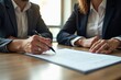 © Vera - A professional woman signing a business contract with her attorney, representing a new partnership and legal commitment.