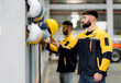 © Montri - Industrial worker selecting safety helmet from PPE rack in factory warehouse. Workplace safety preparation, protective equipment, manufacturing worker and occupational safety concept.