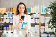 © JackF - Woman in summer clothes scans code on medicinal mouthwash to check the expiration date