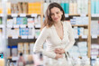 © JackF - Woman visits pharmacy and suffers from abdominal pain. Customer is looking for affordable remedy to relieve cold symptoms. Patient feels sick, pharmacy client is worried about menstrual pain
