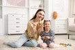 © New Africa - Mother and her daughter playing with toys on floor at home