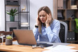 © New Africa - Woman feeling fatigue at wooden desk in office