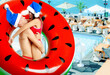 © New Africa - Happy couple with Santa hats and inflatable ring against swimming pool at sea resort
