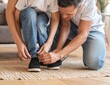 © Office - Caring father tying shoelaces for his young son at home.