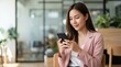 © The Usable Stock - Charismatic Pan-Asian Professional Typing on Smartphone with Copy Space