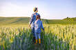 © sofiko14 - A mother and her daughter walk through a golden wheat field under a clear blue sky, enjoying a serene rural landscape