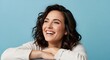 © Designer - Cheerful young woman with wavy brown hair laughing, happy female portrait on blue background, joyful person expressing positivity and wellness