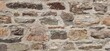 © Freiberufler - A medieval wall made of uneven stones arranged in a structured pattern