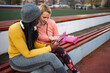 © Jelena - Two diverse women training planning with tablet at stadium