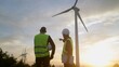 © DawDunia - Engineers in safety vests overlooking a wind turbine farm at sunset, discussing renewable energy development and sustainability for a greener future