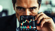 © P.W-PHOTO-FILMS - A man peers intensely at a stock chart displayed on his phone, showcasing a dramatic market trend.