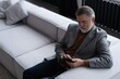 © opolja - Mature smiling man using smartphone