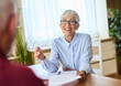 © Lumos sp - Portrait of a mature senior businesswoman with contract agreement and pen during meeting in the office