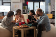 © DC Studio - Multiethnic group of coworkers having conversation at office celebration. Man and women talking and having fun with alcoholic drinks, pizza and chips at party after work hours.