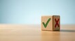 © tonstock - Wooden cube with check mark and cross symbols on a desk representing decision making and feedback.