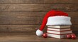 © CreativeBro - Christmas holiday objects with Santa Claus hat and stacked books on wooden background