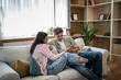 © Migma_Agency - Young couple sharing smartphone content on couch at home