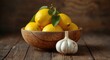 © vxnaghiyev - Bright lemons gathered in a bowl beside a plump garlic bulb