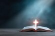 © Andrii Zastrozhnov - Open bible cross light blessing grace glowing cross above scripture with sparkling particles and radiant beam