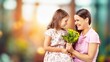 © BillionPhotos.com - Happy women's day. Child congratulating mom with flowers.
