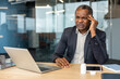 © Liubomir - Mature businessman at modern office desk presses his temple in pain beside laptop and pill bottle, showing headache, stress and workplace overload during a tense workday