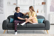 © New Africa - Happy couple in pajamas spending day together on sofa at home