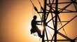 © Umana - Lineman working on power transmission tower at sunset