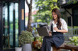 © apichat - Asian woman entrepreneur working on laptop outdoors
