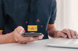 © fadfebrian - A man receiving a message on his smartphone with a warning symbol. Phishing, scam, or spam alert concept.