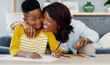 © peopleimages.com - Mother, kid and hug in home with homework, education support and writing task for child development. Black people, mom and son in house with school assignment, learning and embrace for encouragement.