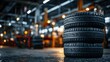 © horizon - Stack of brand new premium black car tires with deep sharp treads resting in a softly lit well-organized professional auto repair garage.