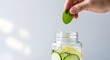 © Jannat00 - Refreshing cucumber and lemon infused water on a light background
